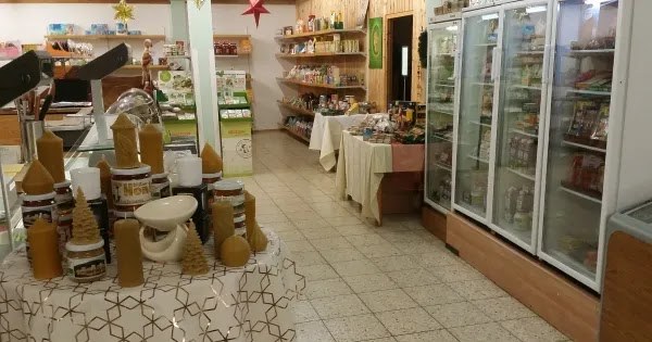 Tisch mit handgefertigten Bienenwachskerzen vor den Kühlschränken im Laden